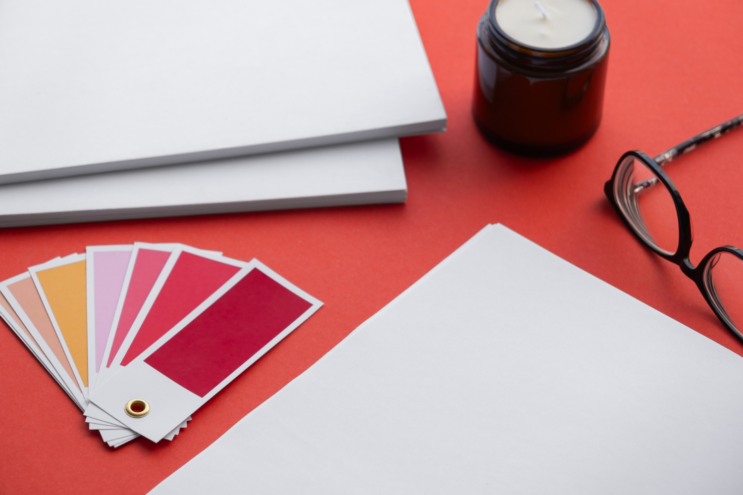 Colour swatches, stationery and glasses on a design studio desk